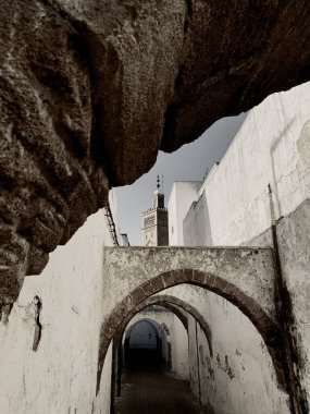 Beyaz binalar arasındaki dar tünel benzeri dar bir yol.