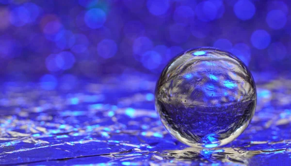 Een Glazen Bol Met Reflectie Van Blauw Oppervlak Bokeh Verlichting — Stockfoto