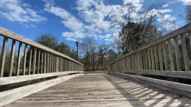 Mavi gökyüzünde hareket eden bulutlar ahşap bir köprünün üzerinde