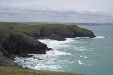 İngiltere, Cornwall 'da denizin yanındaki yeşil bir tepenin havadan çekilmiş görüntüsü.