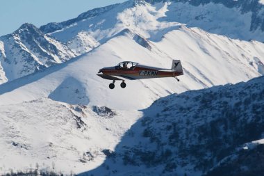 Karlı dağların üzerinde uçan bir uçak