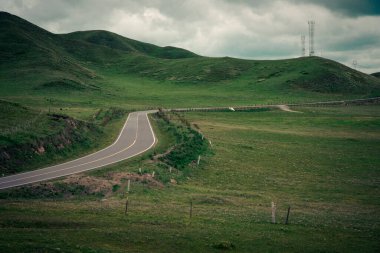 Yeşil tepelerde yolu olan güzel bir manzara.