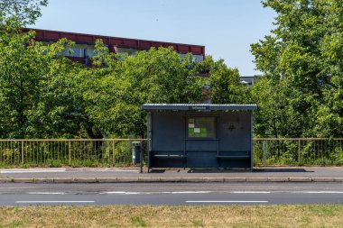Güneşli bir günde yol kenarında boş bir otobüs durağı..