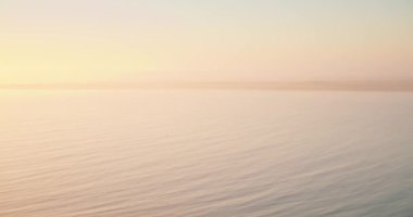 Gün doğumunda berrak gökyüzünün altında sakin bir denizin güzel manzarası.