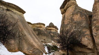 Kapadokya 'da karla kaplı kayalık jeolojik oluşumlar.