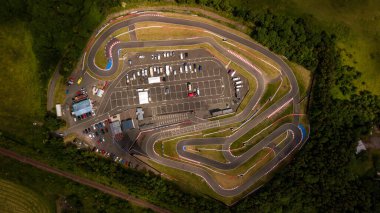 Park etmiş arabaların olduğu bir yarış pistinin havadan görüntüsü.