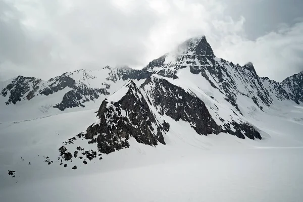 白雪の山の近くの白い雲の美しいショット — ストック写真