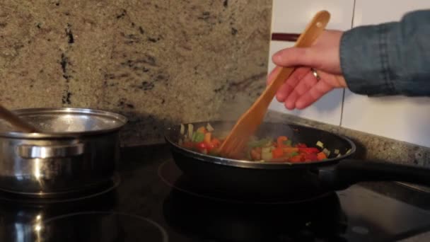 家庭でフライパンで料理をかき混ぜて食べる人の手 — ストック動画