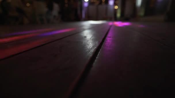 Nahaufnahme Eines Holzfußbodens Auf Dem Sich Bunte Lichter Bewegen — Stockvideo