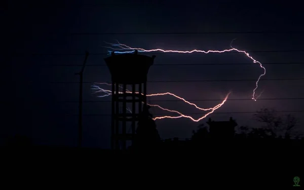 ユーティリティポールのシルエットに対して暗い夜空に稲妻の景色 — ストック写真