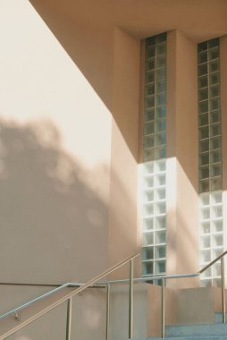 Binanın dış kısmının dikey görüntüsü, bej duvardaki cam blokların dikey tasarımı