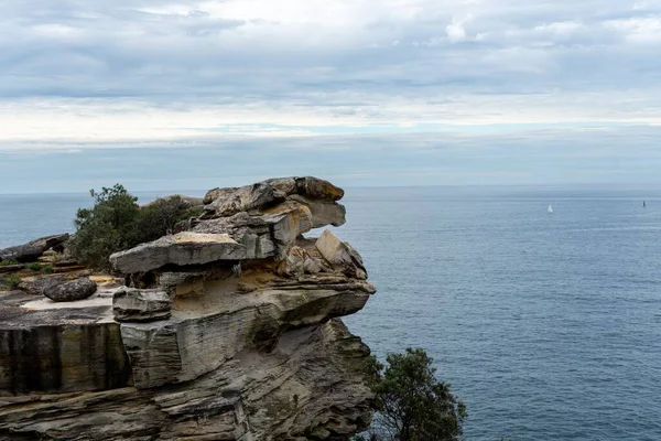 Malowniczy Widok Skalistego Urwiska Pokrytego Zielenią Przeciw Błękitnemu Morzu — Zdjęcie stockowe