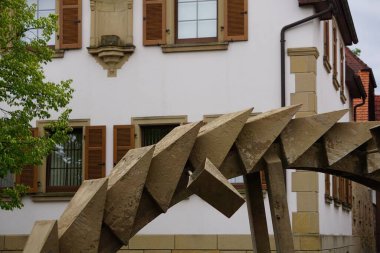 Arka planda eski ve güzel bir bina olan rustik metal yuvarlak bir teçhizatın yakın plan çekimi.