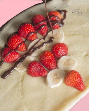 Muzlu, çilekli ve çikolatalı krep manzarası.