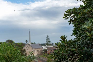 Eski bir şapele ve kasvetli bir günde evlere karşı seçici bir yeşil bitki odağı