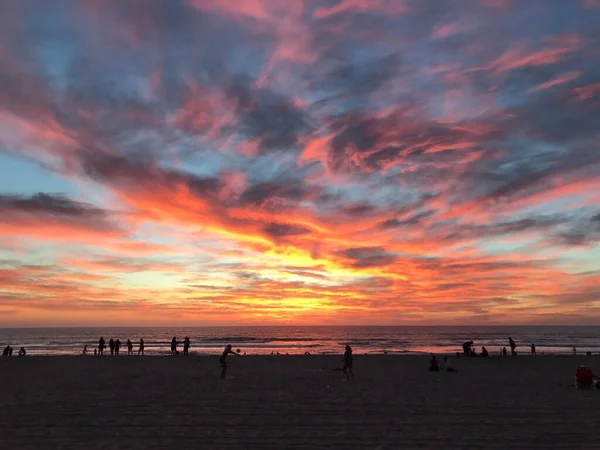 人々で賑わうビーチでの美しい夕日 — ストック写真