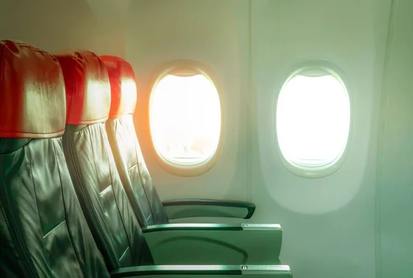 一张空的飞机真皮座椅的照片 后座上有红色的头枕和窗户 — 图库照片