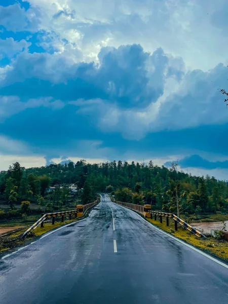 Tiro Vertical Uma Estrada Asfalto Molhada Sob Céu Azul Que — Fotografia de Stock