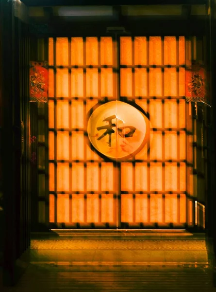 中国传统大门的一个垂直截图 具有与橙色照明相映成趣的字符 — 图库照片