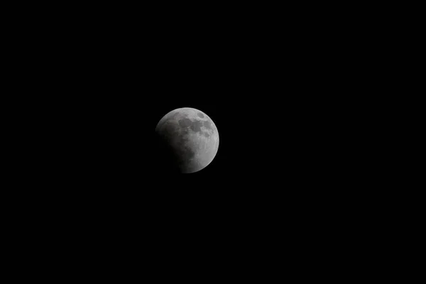 满月在漆黑的夜空中与日食分离 — 图库照片