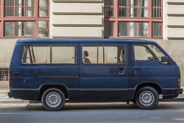 Şehrin caddesinde park edilmiş eski mavi bir minibüs. Toyota Hiace
