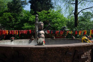 Küçük bir fıskiyede kaldırılmış bir Buda heykeli resmi.