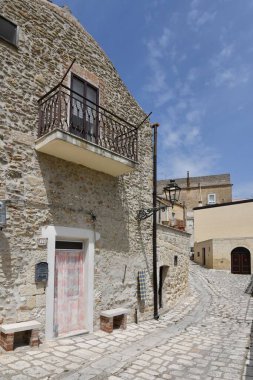İtalya 'nın Matera ilindeki bir köy olan Irsina' nın eski evleri arasında küçük bir sokak..