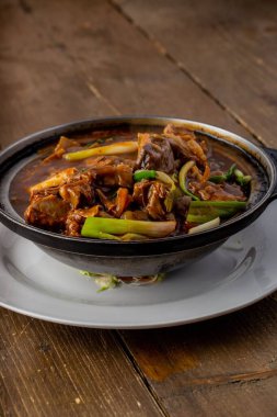 Bir kasede et ve sebze servisi.