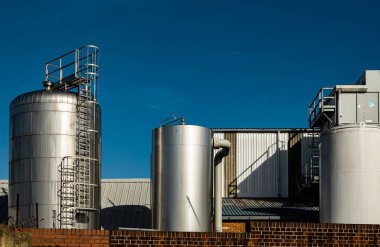 Eski bir bira fabrikasının dev metal tankları Faversham, Kent, İngiltere 'de açık mavi bir gökyüzüne karşı.