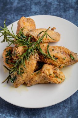 Düz tabakta baharatlı ve biberiyeli kızarmış tavuk kanadı.