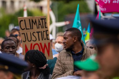 Black African man demands climate justice at demonstration. G7 summit protest in Munich, Germany clipart