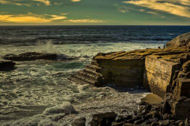 Los Angeles Jolila California yakınlarında kayalıklarda küçük bir dalga kırıcı ile kayalık bir dükkan.