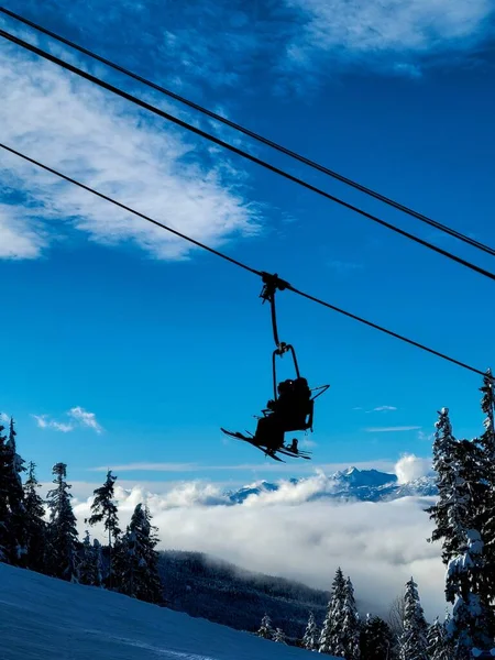 Een Verticale Lage Hoek Schot Van Skiërs Silhouet Stoeltjeslift Blauwe — Stockfoto