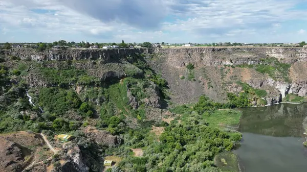 Bulutlu bir günde ağaçlı ve göllü güzel bir kanyon manzarası.