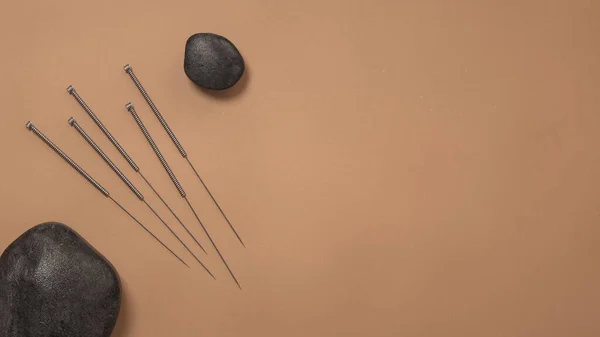 针灸针和石子在棕色表面上的三维绘制 — 图库照片