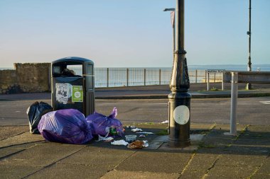 Sokakta, direğin yanında çöp dolu plastik torbalar. Ramsgate, Birleşik Krallık.
