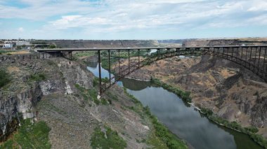 Dağlar arasında nehrin üzerindeki bir köprü manzarası.