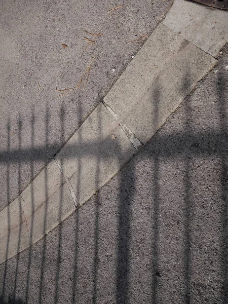 歩道に反射するフェンスの影の素敵な写真 — ストック写真