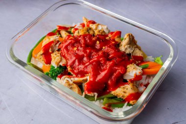 Domates soslu pirinç ve sebzelerle hazırlanmış bir tavuğun yakın çekimi.