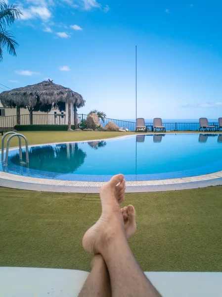 Vertikal Persons Fötter Liggande Mot Swimmingpool Som Reflekterar Strandstolar Och — Stockfoto