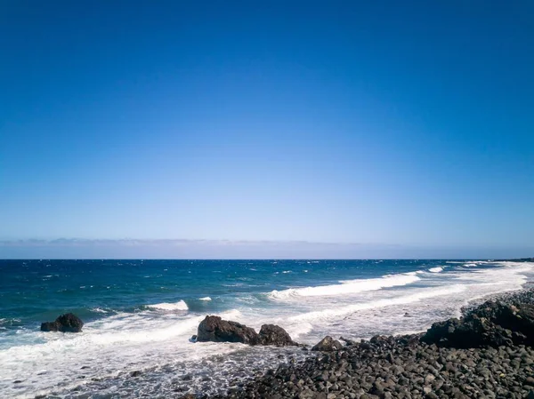 テネリフェ島の青い海の波に対する岩の多いラ ヴィウダビーチの景色 — ストック写真