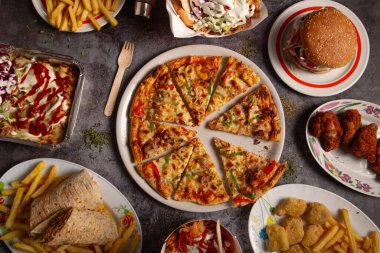 Pizzanın ve sokak yemekleri çeşitlerinin üst görüntüsü.