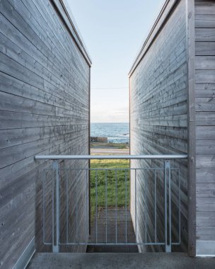 İki ahşap bina arasındaki kapının dikey görüntüsü.