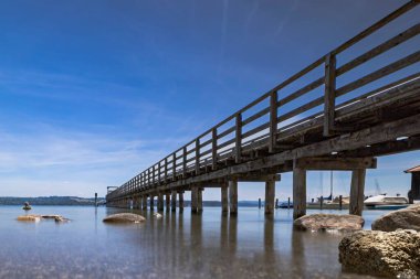 Mavi gökyüzü arkaplanına karşı uzun rıhtımın alçak açılı görüntüsü
