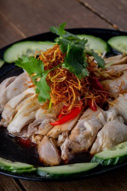 Salatalıkla servis edilen sosta haşlanmış tavuk dilimleri.