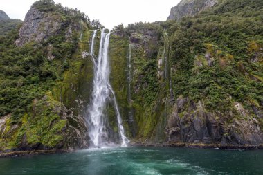 Yeni Zelanda 'nın Güney Adası' ndaki Milford Sound Fiord 'da nefes kesici bir şelale manzarası.