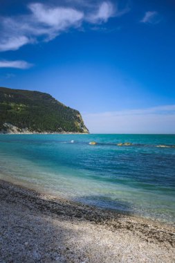 Mavi gökyüzünün altında güzel mavi bir okyanusun dikey görüntüsü.