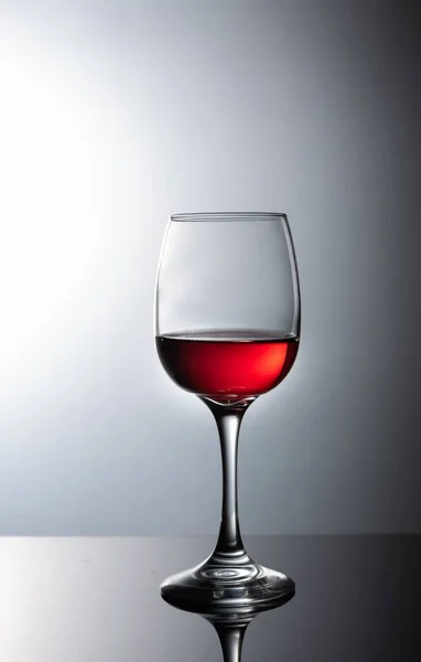 灰色の背景にワインのガラス — ストック写真