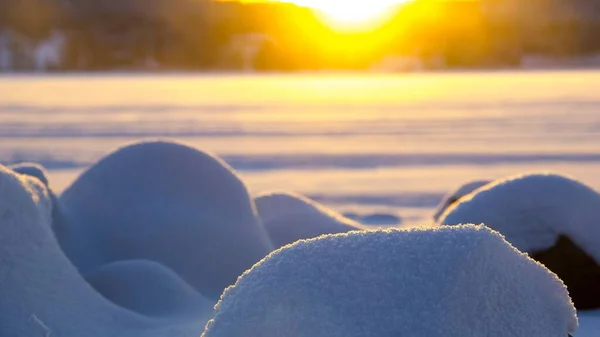 日落时被雪覆盖的石头的特写镜头 — 图库照片