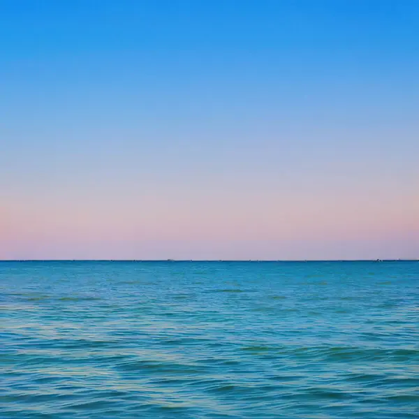 Piękny Widok Spokojnego Morza Pod Czystym Niebem Wschodzie Słońca — Zdjęcie stockowe